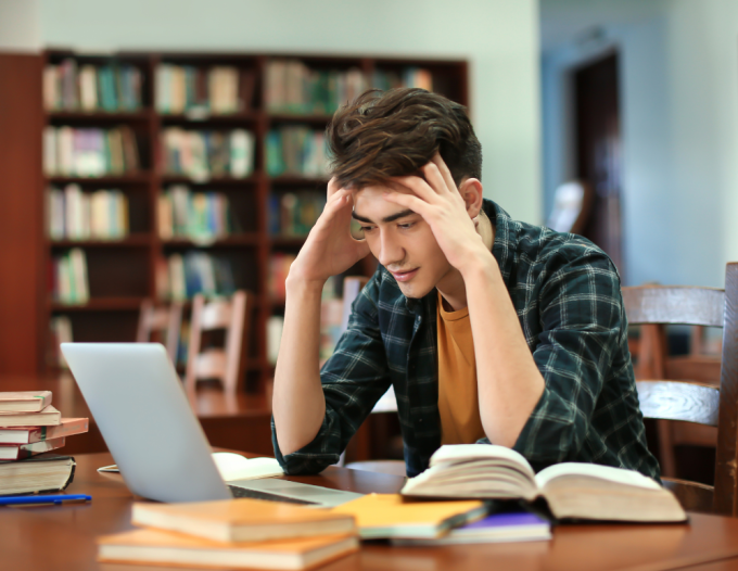 Man studying while holding head.