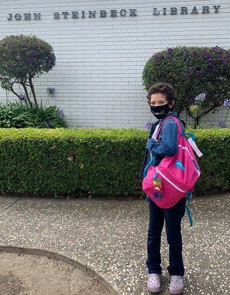 One of the winners picks up her prize, proudly showing the backpack in front of the John Steinbeck Library. Congratulations!
